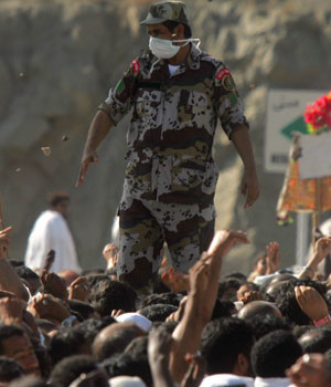 A Saudi police officer directs Muslim pilgrims throwing stones at a pillar representing the devil during the hajj, in Mena, Saudi Arabia, Jan. 10, 2006 (AP)