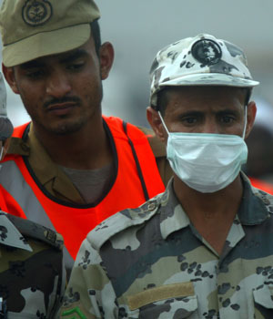 Saudi security officers look at the dead bodies of victims of a stampede in Mena, Saudi Arabia, January 12, 2006 (AP)