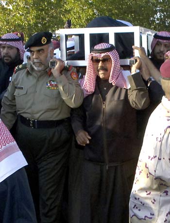 Family members of late Sheikh Jaber al Ahmed al-Sabah carries his body to his resting place in Kuwait (R)
