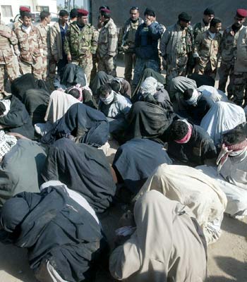 Insurgents sit on the ground after being arrested in the village of Gurna, 80 kms south of Basra (AFP)