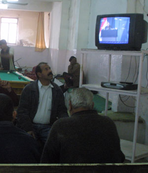 Iraqis watch member of Iraq's electoral commission Safwat Rashid reading the election results on TV at a coffee shop in Baquba, 60kms northeast of Baghdad, 20 January 2006 (AFP)