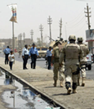 US soldiers and Iraqi police secure the scene of the car bomb in Shula, a predominantly Shiite area of northern Baghdad (AFP)