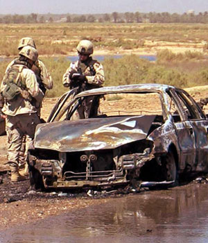 US soldiers view wreckage at scene of car bomb attack near Baquba (REUTERS)