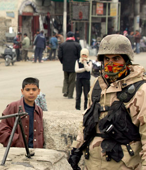 An Iraqi soldier secures a busy street during a patrol in central Baghdad, 02 February 2006 (AFP)