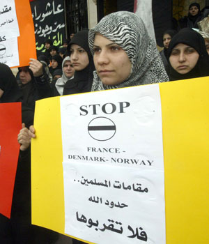 Muslim students hold up signs calling on people to respect the holy figures and sanctuaries of Islam, over the publication of cartoons of the Prophet Mohammed deemed offensive to Islam, Saida, Lebanon (AFP)