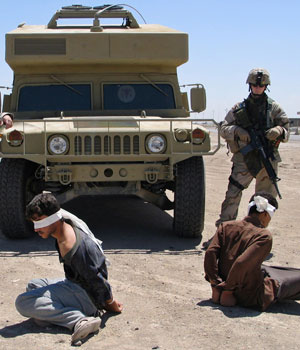 US soldier keeps watch on two men suspected of car bomb attack in northern Iraq town of Baquba (REUTERS)