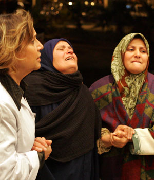 A wailing relative, center, is helped up the steps to the hospital in the port of Hurghada in Egypt, Feb. 4, 2006 (AP)