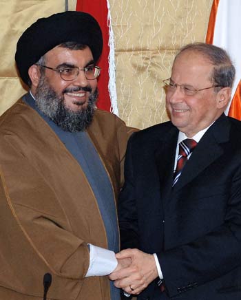 Hezbollah leader Sheik Hasan Nasrallah, left, shakes hands with Lebanese Christian legislator Michel Aoun (AP)