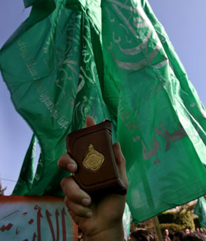 A Palestinian supporter of Hamas holds a copy of the koran during a protest against cartoons depicting Prophet Mohammad, which were published in several European newspapers, in front of the Palestinian parliament in Gaza Strip February 7, 2006 (REUTERS)