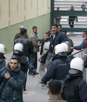 Unemployed Palestinian security forces protest in front of the ministry of finance as policemen chase them, 09 February 2006 in Gaza City (AFP)