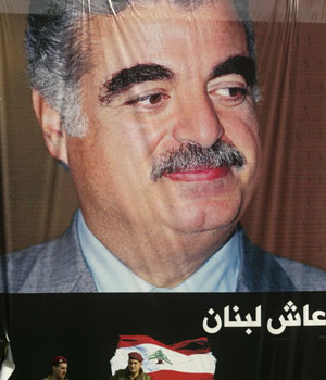 Lebanese soldiers stand underneath a portrait of slain premier Rafik Hariri during a mass gathering to mark the first anniversary of Hariri's assassination in central Beirut, 14 February 2006 (AFP)