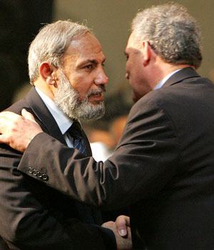 Mahmoud al-Zahar, a senior Hamas member in the Palestinian parliament, hugs his fellow parliamentarian Zead Abu Amir (R) during the parliament meeting in Gaza February 18, 2006 (REUTERS)