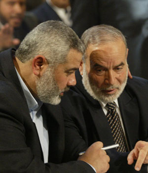 Hamas leader Ismail Haniyeh speaks with Ahmed Bahar during the inaugural session of the Palestinian Parliament in Gaza City, 18 February 2006 (AFP)