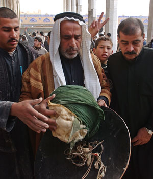 Iraqis inspect what appears to be the shield and turban of 9th century Shiite Imam Ali al-Hadi in a damaged shrine following an explosion in Samarra, 95 kilometers (60 miles) north of Baghdad, Iraq, Feb. 22, 2006 (AP)