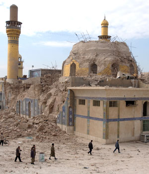 Iraqis walk past the damaged shrine following an explosion in Samarra, 95 kilometers (60 miles) north of Baghdad, Feb. 22, 2006 (AP)