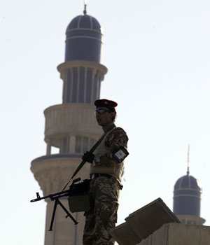 An Iraqi soldier holds a weapon to provide security on top of a Sunni mosque in Baghdad February 23, 2006 (REUTERS)