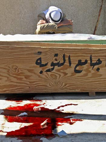 An Iraqi mourns over the coffin of a relative outside the morgue of a local hospital in Baquba, northeast of Baghdad (AFP)