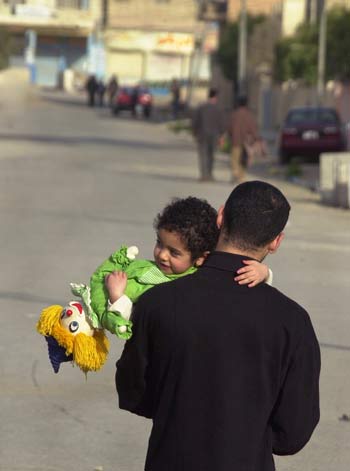 An Iraqi father takes her daughter for a stroll as the curfew was relaxed for few hours, in Baqouba (AP)
