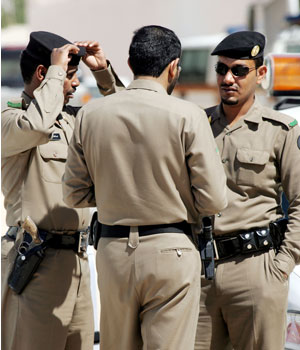 Saudi security forces stand guard on a road leading to the house where five men were killed during clashes in Riyadh, 27 February 2006 (AFP)