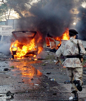 A Pakistani paramilitary soldier rushes at a bomb blast site after bomb exploded outside a five star hotel near the American consulate in Karachi, 02 March 2006 (AFP)