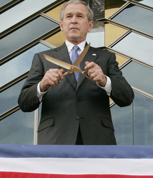 President Bush wields a pair of golden scissors before cutting a ribbon to officially open the U.S. Embassy in Kabul, Afghanistan, March 1, 2006 (AP)