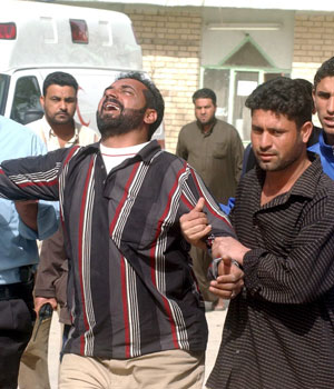 An Iraqi man mourns his relative who was killed by mini bus explosion, outside a local hospital morgue in Al-Sadr city, 02 March 2006 (EPA)