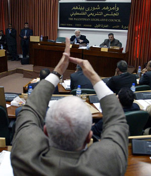 A Palestinian MP raises his hand to speak as Hamas' Palestinian parliamentary speaker Aziz Dweik chairs the Palestinian Legislative Council (PLC) 06 March 2006 (AFP)