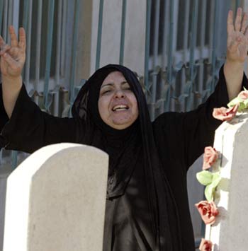The wife of Amjad Hameed, a senior Iraqi state television editor, weeps during his funeral in Baghdad March 11, 2006 (R)