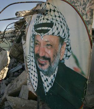 A portrait of late Palestinian leader Yasser Arafat is seen in the rubble of the prison damaged during an Israeli army raid in the West Bank town of Jericho, March 15, 2006 (AP)