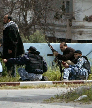 Palestinian policemen take up position during exchange of fire with Palestinian gunmen after they blocked a main Gaza road, March 20, 2006 (REUTERS)