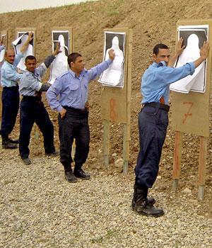 Iraqi police recruits check their targets at a shooting range in their compound in the northern city of Suleimanya, 20 March 2006 (AFP)
