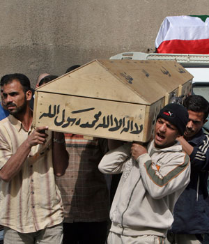 Relatives and friends carry the bodies of Iraqis for burial, killed by drive-by shooters, in Baghdad, Iraq, March 24, 2006 (AP)