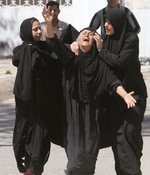 Iraqi women console an elderly lady, whose only son, an Iraqi policeman, was injured during a car bomb explosion, in Baghdad, Iraq, March 23, 2006 (AP)