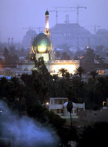 Smoke rises from burning garbage under the Iraqi Bunnia Sunni mosque illuminated at dusk in Baghdad (AFP)