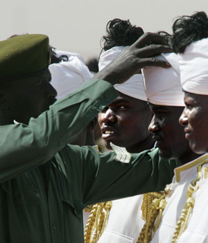A royal guard adjusts the turban of a honour guard in a line-up to welcome arriving Arab heads-of-state at Khartoum airport on the eve of the Arab League summit, 27 March 2006 (AFP)