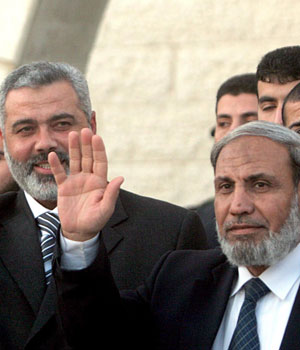 Palestinian Prime Minister Ismail Haniya (L) stands next to Foreign Minister Mahmud al-Zahar (R) as they arrive to the swearing-in ceremony in Gaza City, 29 March 2006 (EPA)