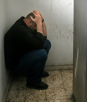 A Palestinian holds his head in grief at the morgue near the body of Abu Yousef Abu Quka, a Popular Resistance Committees commander killed in Gaza City, March  31, 2006 (AP)
