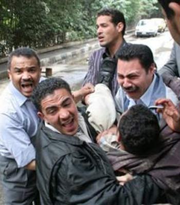 An injured man is carried away after competing factions, fighting over the leadership of Egyptian political party 'al-Wafd' (AP)