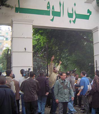 Supporters of the Wafd (liberal) party struggle in front of the party headquarters in Cairo (AFP)