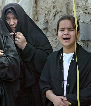 Iraqi women mourn the death of a child at the site where a roadside bomb exploded in Baghdad, 04 April 2006 (AFP)