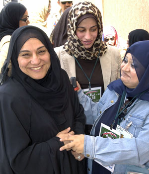 Female Kuwaiti candidate Khaleda Al Khadher (L) jokes with a supporter at a polling station in Roumaithya district in Kuwait April 4, 2006 (REUTERS)