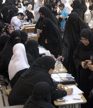 Kuwaiti women check with their candidate's representative before entering a polling station to cast their ballot for municipal council elections in Roumaithiya, Kuwait, April 4, 2006 (REUTERS)