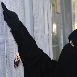 A Kuwaiti woman looks for her name on a list that will designate where she will cast her vote for municipal council elections at a polling station in Roumaithiya, Kuwait April 4, 2006 (REUTERS)