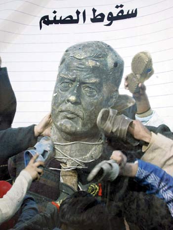 Iraqis hold a placard showing children beating a Saddam Statue during a demonstration organized to mark the third anniversary of the toppling of Saddam Hussein's regime (EPA)
