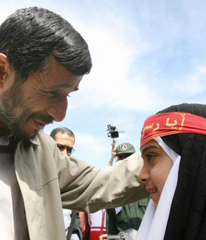 Iranian President Mahmoud Ahmadinejad greets a schoolgirl in Ferdos in Khorasan Razavi province, north east of Tehran, Iran, April 13, 2006 (AP)