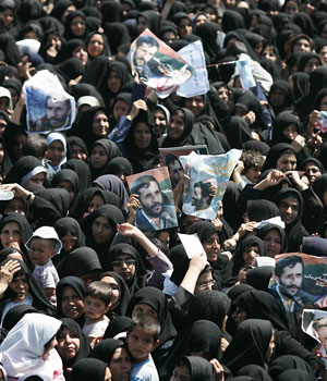 A crowd of Iranian women carry portraits of Iran's President Mahmoud Ahmadinejad during his visit to the town of Kashmar in Iran's northeastern province of Khorassan, 13 April 2006 (AFP)