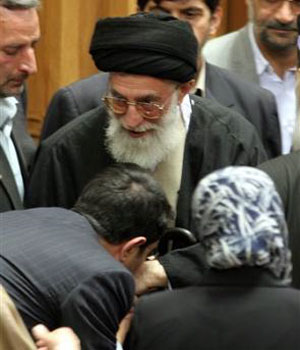 A participant kisses the hand of Iran's supreme leader Ayatollah Ali Khamenei, as he leaves a conference for supporting the Palestinians, after delivering his speech, in Tehran, Iran, April 14, 2006 (AP)