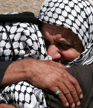 Iraqi men mourn for a relative killed Monday by unknown gunmen, and found in the Dora neighborhood Tuesday April 18, 2006 in Baghdad (AP)