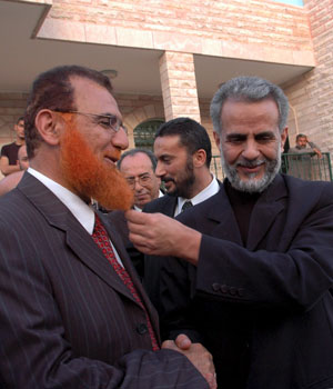 Palestinian Hamas lawmaker Mohammed Abu Tir (L) jokes with Ibrahim Tzartzur (R), an Israeli-Arab Knesset member as they meet outside Tir's Arab East Jerusalem home, April 19, 2006 (EPA)