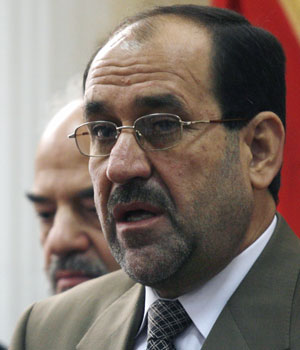Iraqi politician Jawad al-Maliki stands next to embattled Iraqi Prime Minister Ibrahim al-Jaafari during a news conference in Baghdad, April 22, 2006 (REUTERS)